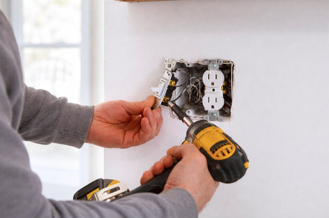 Electrician installing a new electrical outlet in a wall