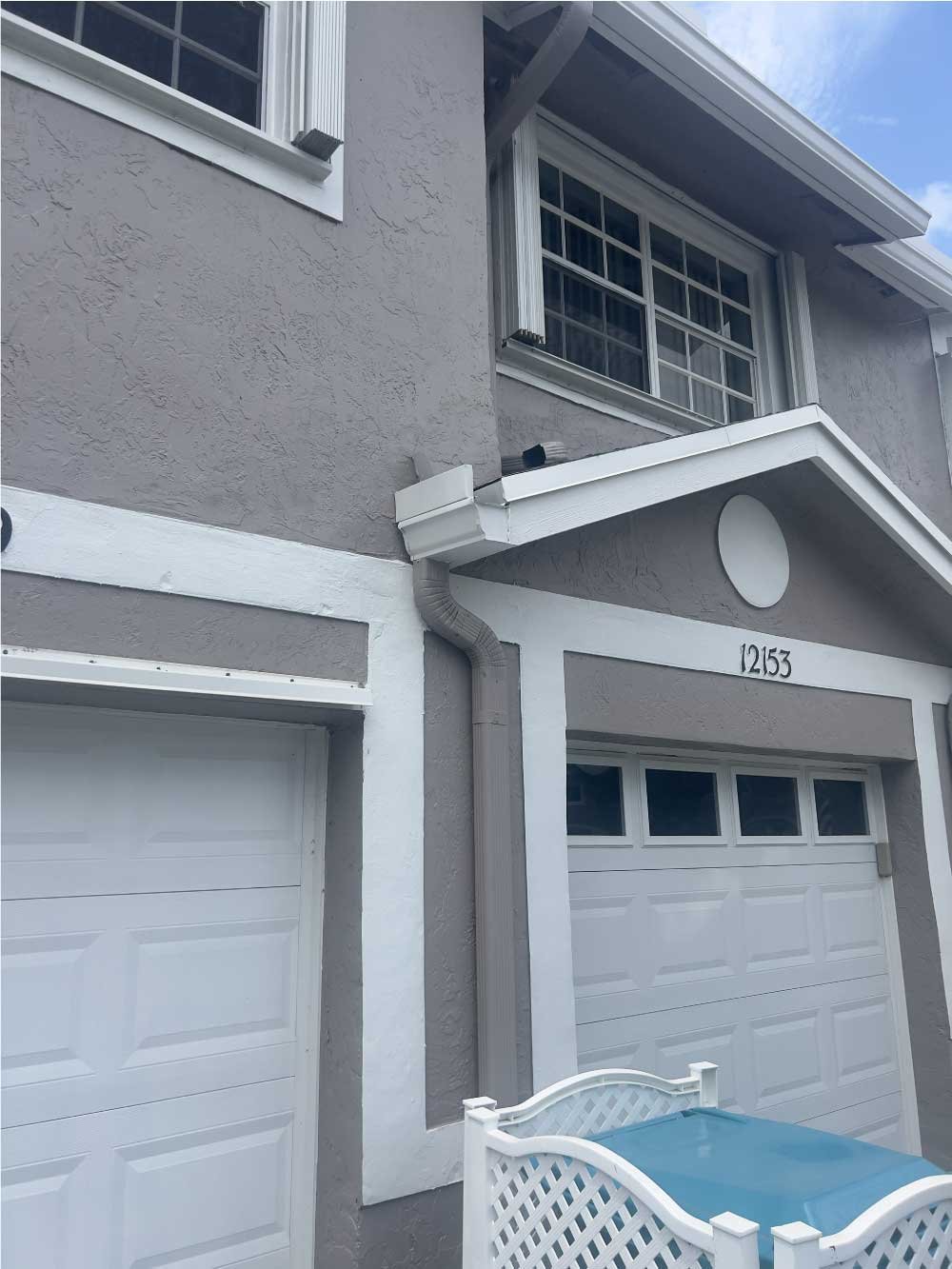 Two-story townhouse exterior with garage doors and entry trim
