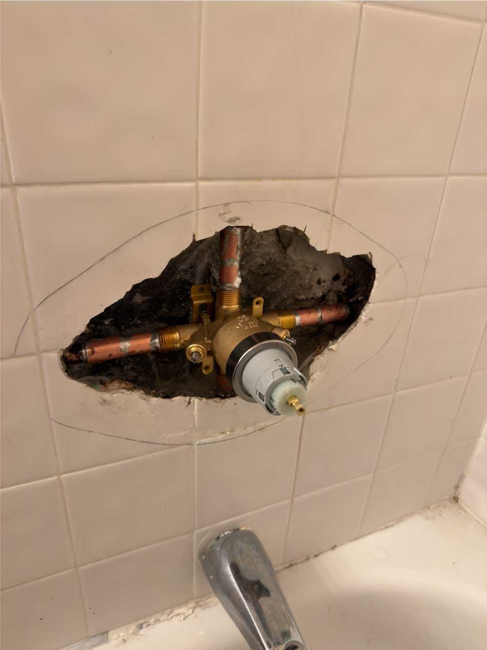 Shower valve replacement with tile opened above a bathtub