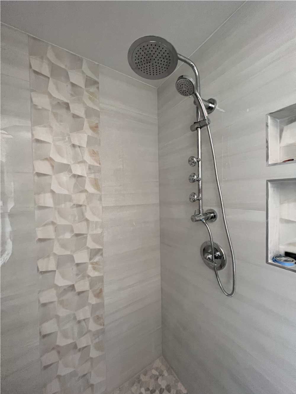 Remodeled walk-in shower with tile surround and a rain shower head