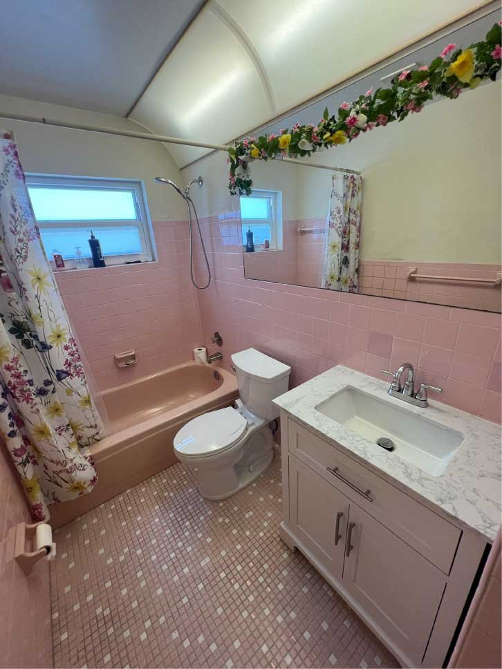 Dated pink bathroom with a new vanity installed during a remodel