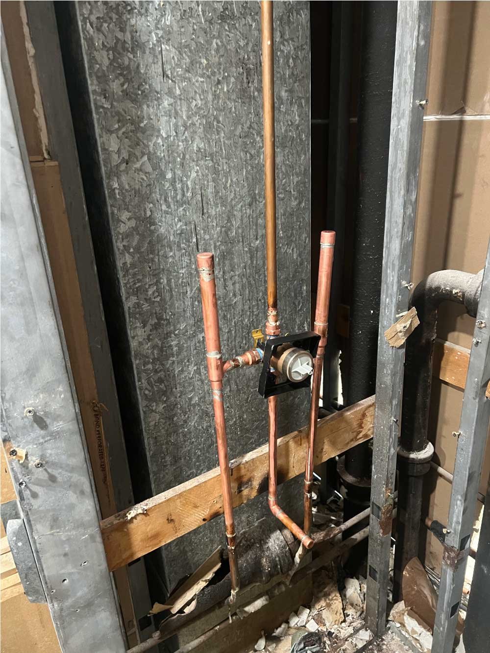 Copper water lines exposed in an open wall during a repiping repair