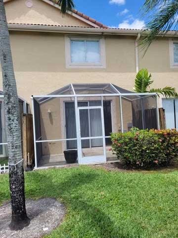 Single-family home exterior with a screened patio enclosure