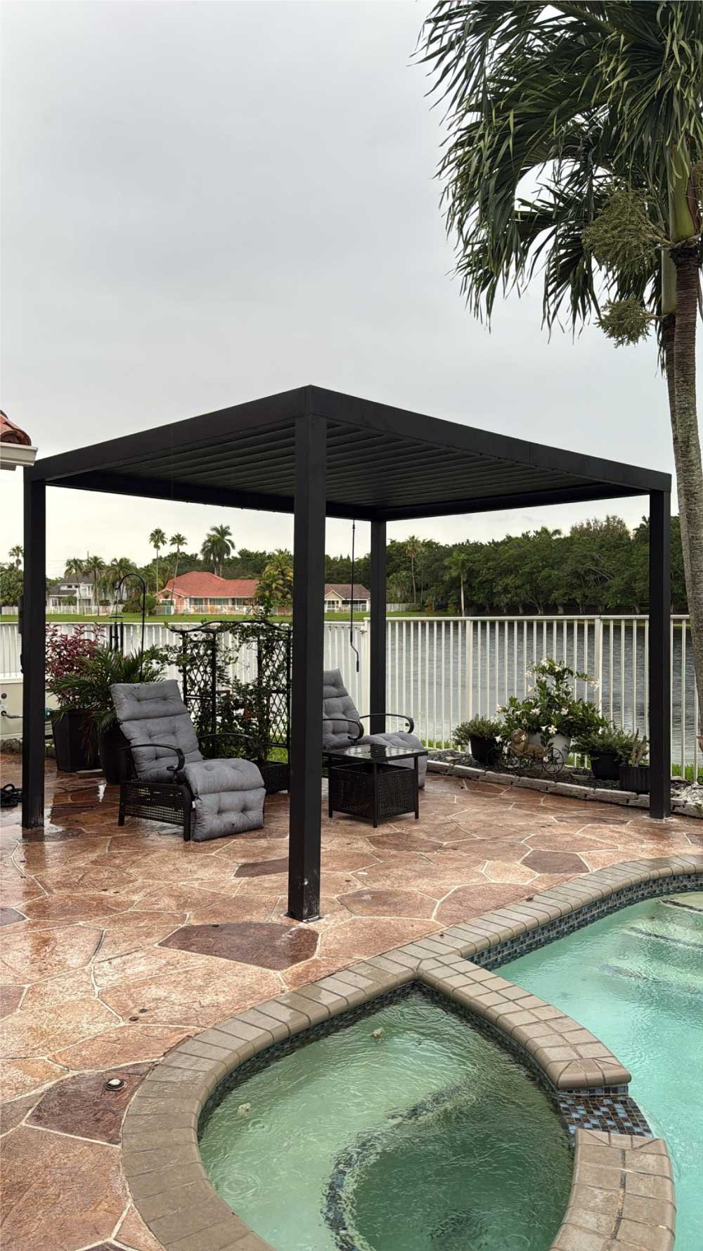 Backyard pool patio with a newly installed pergola and seating area