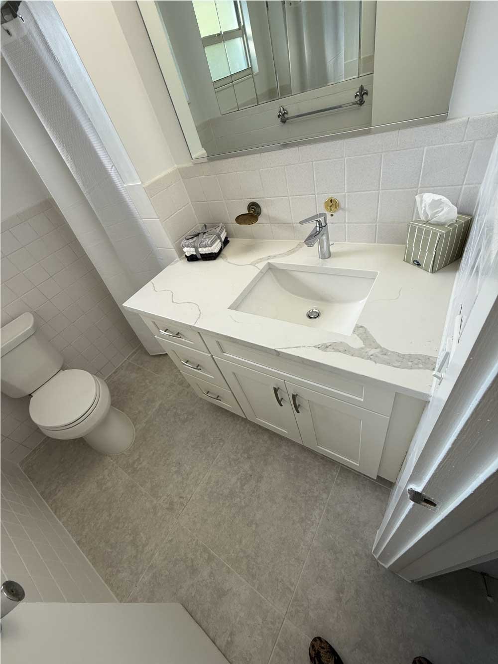 Remodeled bathroom with a white vanity, sink and toilet