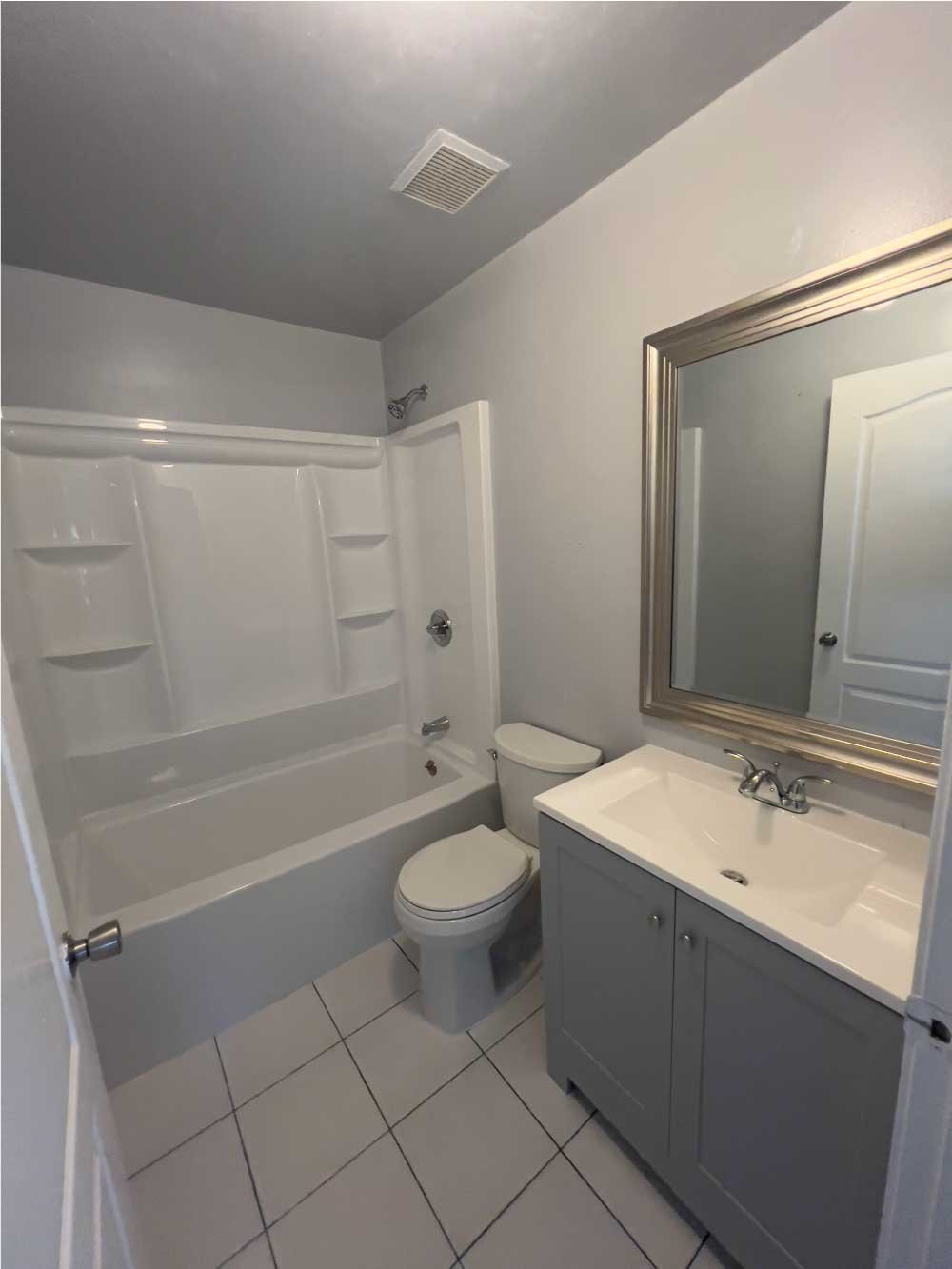 Full bathroom with a tub-shower combo, vanity and toilet after a remodel